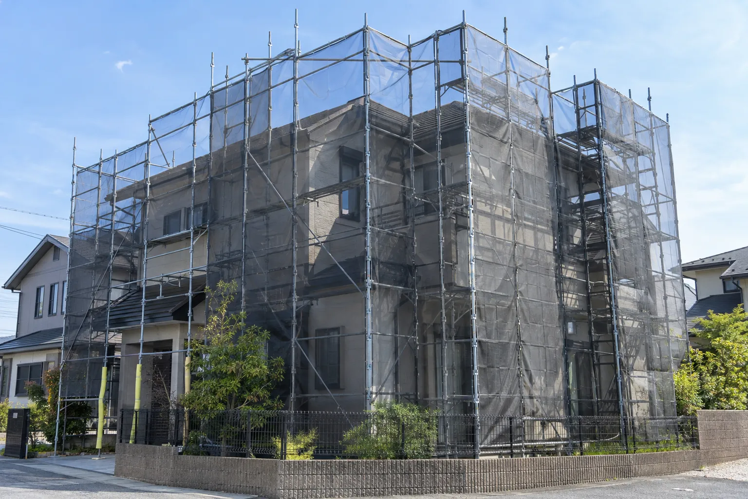 外壁と屋根へ安全に作業できる足場を設置した住宅