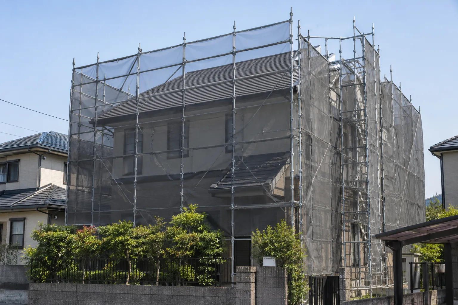 外周足場と飛散防止メッシュを設置した住宅
